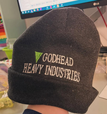 A beanie featuring the logo from the fictional company "godhead heavy industries"